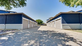 A row of houses with garages on a sunny day.